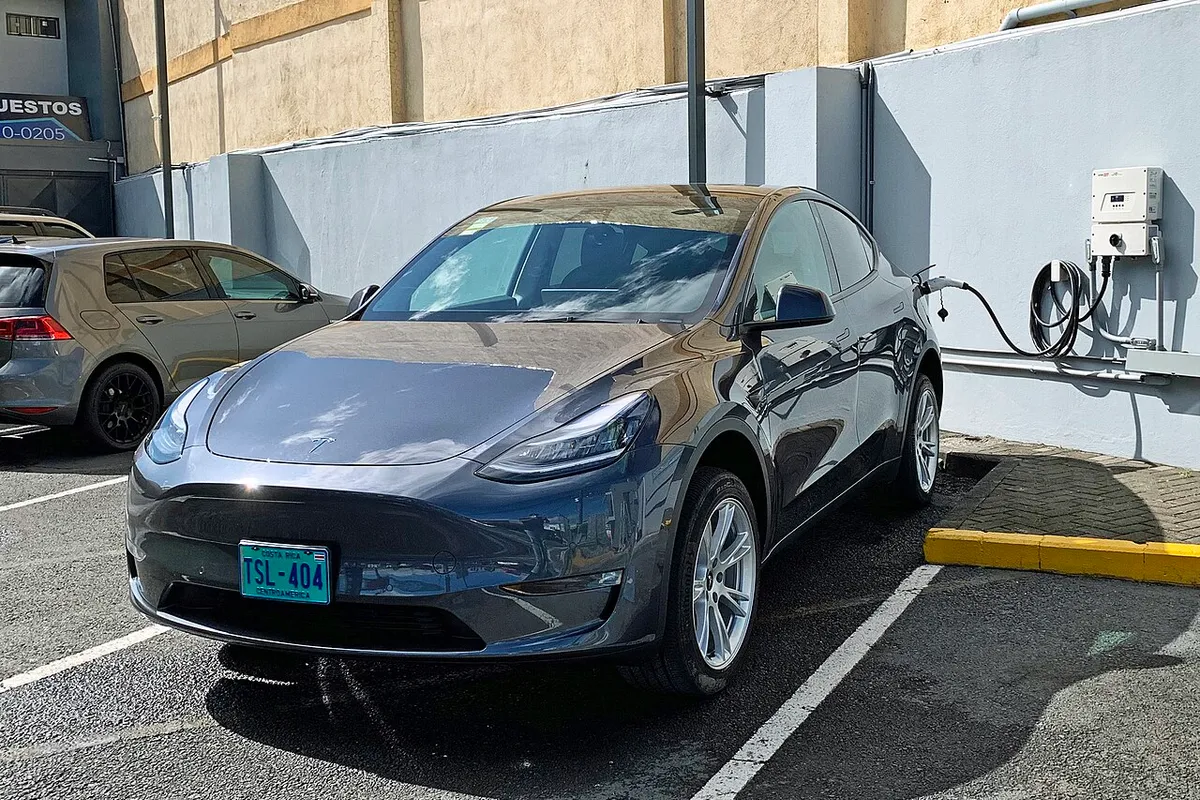 Tesla Model Y all-electric car charging at a Level 2 station in Guadalupe, San José, Costa Rica